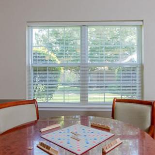 A Scrabble board set up on a wooden table by a window with natural light streaming in.