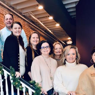A cheerful gathering of friends on the stairs, sharing smiles in a cozy indoor setting.