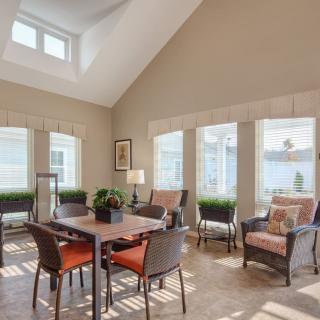 A bright and airy living room featuring a dining area with large windows and contemporary furniture.