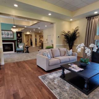 A spacious and elegantly decorated living room featuring a comfortable sofa, a coffee table, and a fireplace.