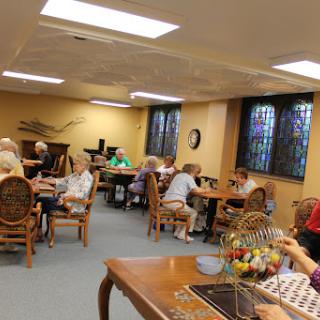 Seniors enjoying a lively game of bingo in a community activity room.