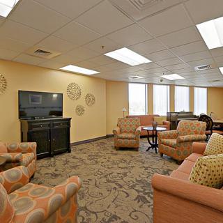 A cozy lounge area with multiple sofas, a television, and decorative elements.