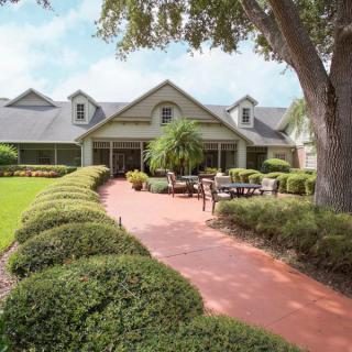 A charming house with a well-maintained lawn and outdoor seating area.