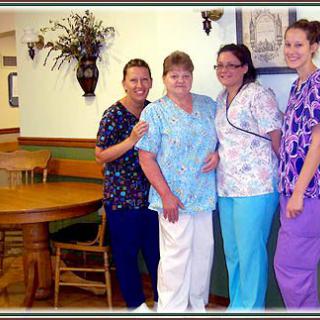 A group of nurses in scrubs posing together indoors.