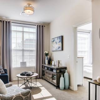 A modern living room with large windows allowing natural light, featuring contemporary furniture and decor.