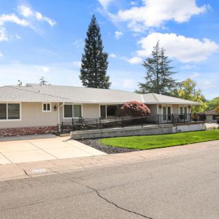 A suburban single-story house with a well-maintained yard and driveway.