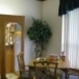 A cozy dining area with a table, chairs, and a potted plant by the window.