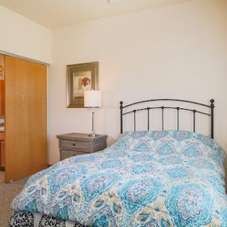 A cozy bedroom featuring a patterned bedspread and charming decor.