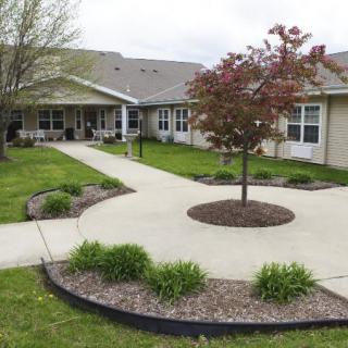 A residential building with a landscaped garden and sidewalk.