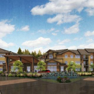 A modern apartment complex surrounded by trees and a clear sky.