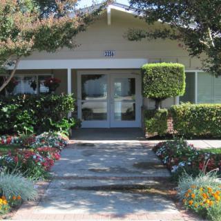 A charming house entrance with well-maintained landscaping and a welcoming garden.