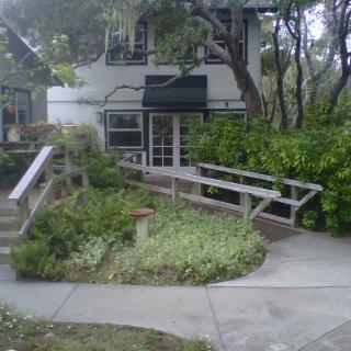 A building with a ramp surrounded by lush greenery and trees.