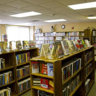 A library interior with rows of bookshelves filled with various books.