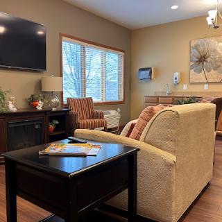 A cozy living room featuring comfortable seating, a television, and natural light from the window.