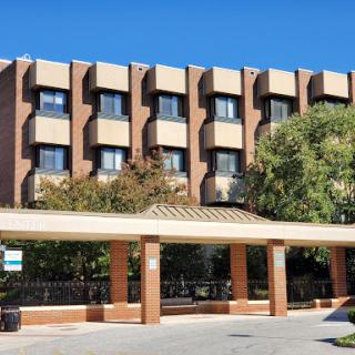 A modern hotel building with a welcoming entrance and lush greenery.
