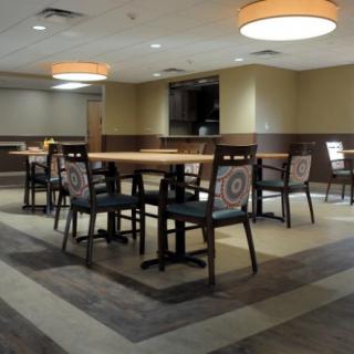 An empty dining area with neatly arranged tables and chairs under soft lighting.