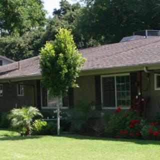 A cozy house with a well-maintained garden and lush greenery.