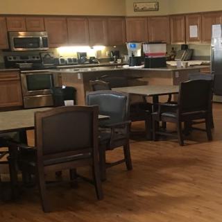 A cozy kitchen and dining area with wooden furniture and modern appliances.