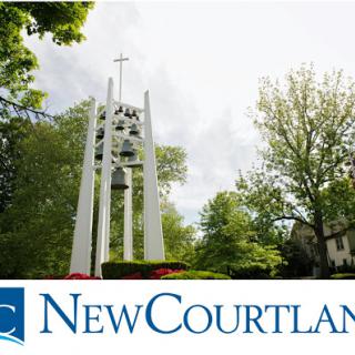 A peaceful view of a bell tower surrounded by lush greenery at New Courtland.