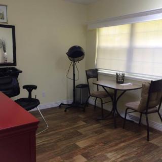 A small office space with a desk, chairs, and a window bringing in natural light.