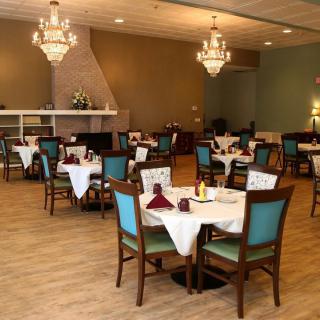 An elegant indoor dining room with neatly arranged tables and chandeliers.