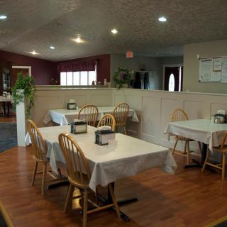 Cozy restaurant interior with neatly arranged tables and wooden chairs.