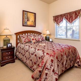 Cozy bedroom with patterned bedding and decorative accents.