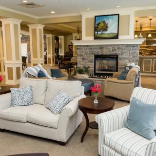 A cozy, well-decorated living room with comfortable seating and a stone fireplace.