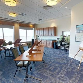 A well-lit conference room with tables and chairs arranged for a meeting.