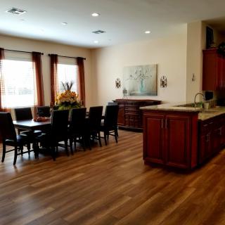 A spacious kitchen and dining area with wooden flooring and elegant furniture.