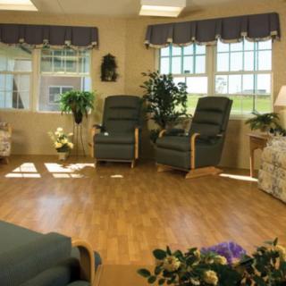 A cozy living room with recliner chairs and large windows.