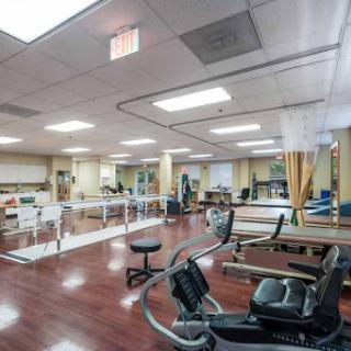 A spacious rehabilitation area equipped with various fitness machines and therapy spaces.