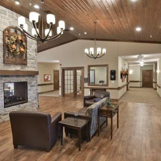 A cozy lobby with a fireplace, seating area, and elegant chandeliers.
