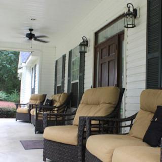 A cozy porch with cushioned chairs and lanterns.