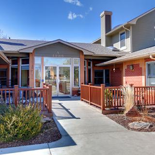 A residential building with a pathway leading up to the entrance on a clear day.