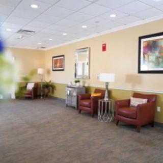 A well-lit lobby seating area with armchairs and decorative artwork on the walls.