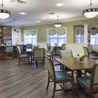 A well-lit dining area with multiple tables and chairs, featuring modern interior design.