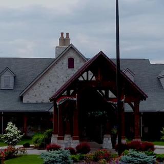 A picturesque stone building with an inviting entrance and well-maintained garden landscape.