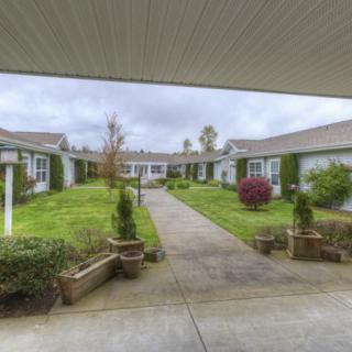 A serene courtyard with a central walkway, surrounded by well-maintained gardens and buildings.