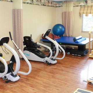 A physical therapy room equipped with recumbent bikes and exercise equipment.