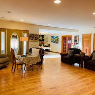 A spacious living room with a dining area, featuring hardwood flooring and comfortable furniture.