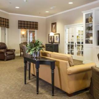 A cozy living room featuring comfortable sofas, armchairs, a table, and elegant decor.