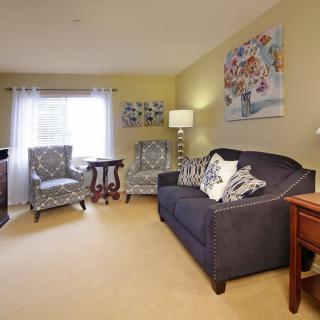 A cozy living room with a sofa, armchairs, and decorative elements that create a warm atmosphere.