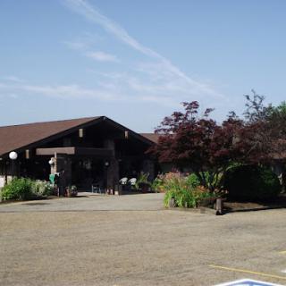 A serene outdoor view showcasing a building with beautiful landscaping under a clear blue sky.