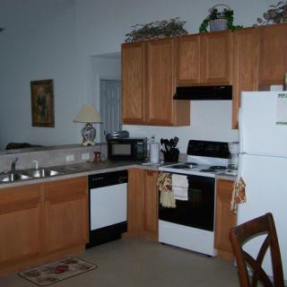 A modern kitchen with wooden cabinets and various appliances.