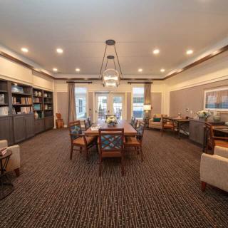 A modern conference room with a large table, comfortable chairs, and elegant lighting.