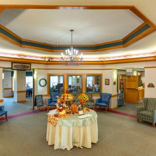 A warmly decorated lobby area with a central table adorned with flowers and surrounded by comfortable seating.