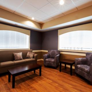 A modern living room with a comfortable sofa, two armchairs, and a wooden coffee table on a hardwood floor.