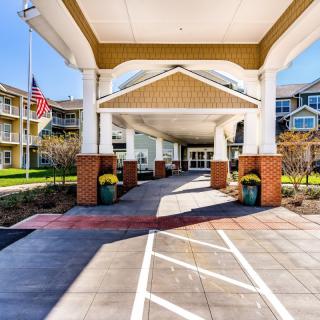 Elegant building entrance with a covered walkway and landscaped surroundings.