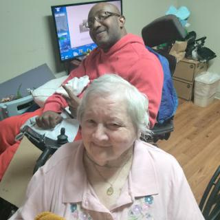 A joyful moment shared between a caregiver and an elderly person, showcasing companionship and support.